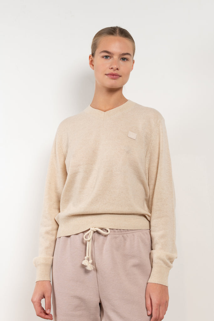 The Wool Vneck Sweater 43 by ACNE STUDIOS features a v-neckline with a ribbed collar, cuff and hem, and completed with a tonal face logo patch