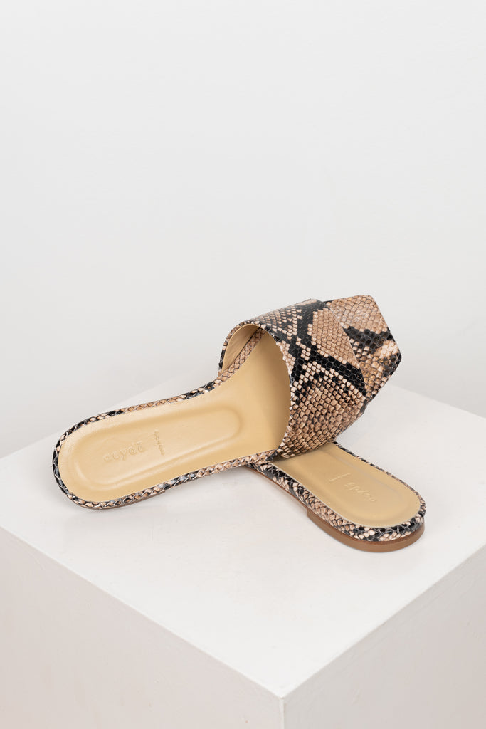 The Anna Slides by Aeyde are iconic lightweight flat slip on sandals with a squared toe, minimal heel in a snake print leather