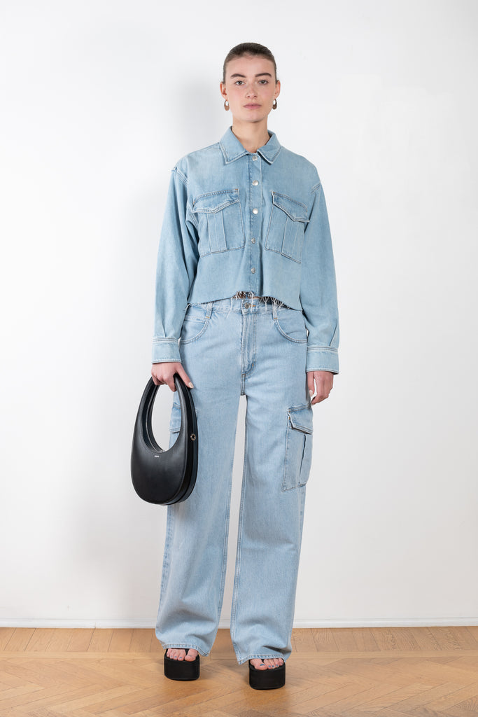 The Nyx Denim Shirt by AGOLDE is a denim shirt with a relaxed, boxy fit, oversized pockets, and a raw hem