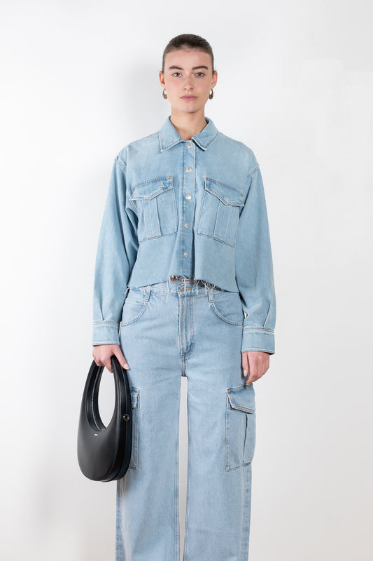The Nyx Denim Shirt by AGOLDE is a denim shirt with a relaxed, boxy fit, oversized pockets, and a raw hem