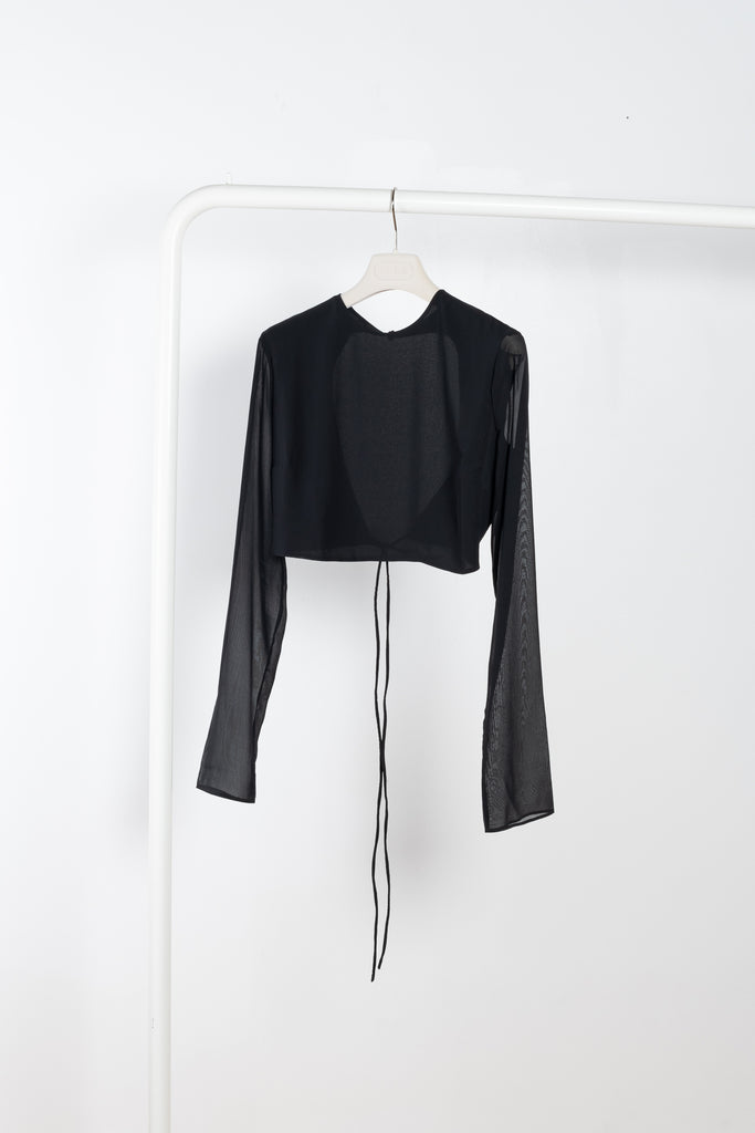 The Lea Top by THE ANDAMANE is a black cropped silk top with a flattering open back