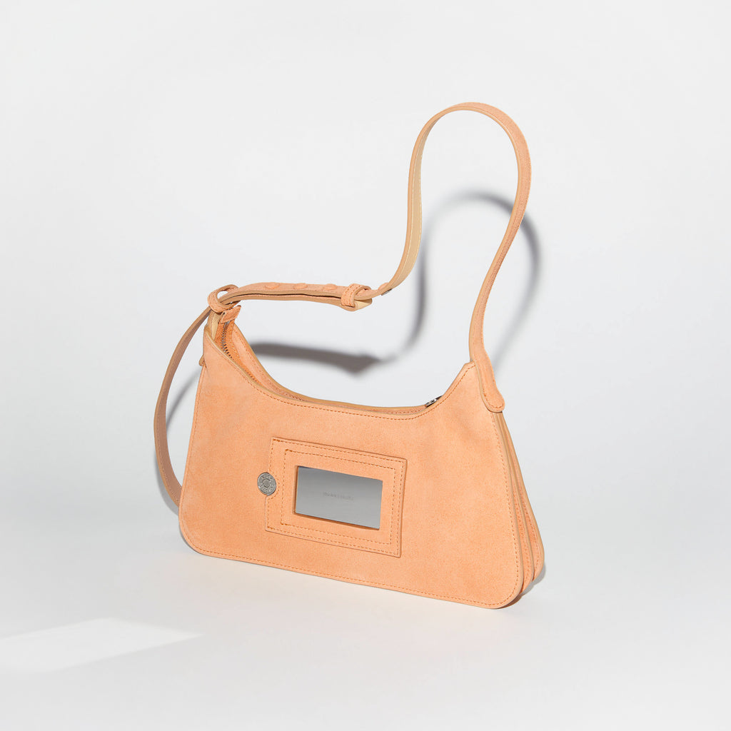 The Platt Mini Bag by  ACNE STUDIOS has a minimalistic silhouette with sculptural folds at the base and sides and is crafted from soft peachy suede and a tonal Acne Studios logo patch