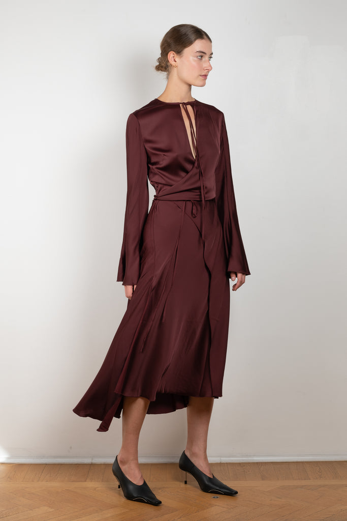 The Satin Dress 776 by ACNE STUDIOS has flared long sleeves, a side slit and asymmetric hem and closes with wrap tie ribbons at the waist