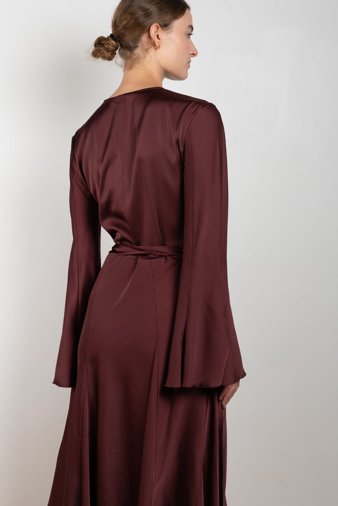 The Satin Dress 776 by ACNE STUDIOS has flared long sleeves, a side slit and asymmetric hem and closes with wrap tie ribbons at the waist