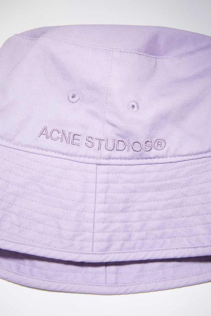 The Twill Bucket Hat 149 by Acne Studios is a lilac bucket hat made out of cotton twill with eyelets, the perfect summer partner