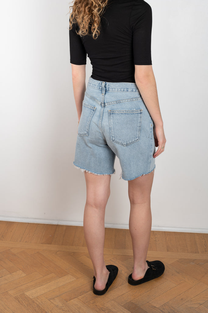 The Fold Waistband Short by Agolde in color sideline has a a mid-rise loose fit, with a front pleat in a light blue wash