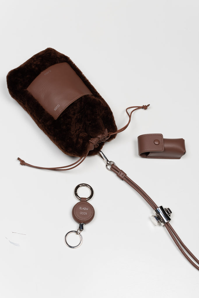 The PXL1JW Shearling Bag by ELAOW is a micro shearling bag to contain your phone, headphones, coins and cards in soft nappa leather with a  jewel strap 