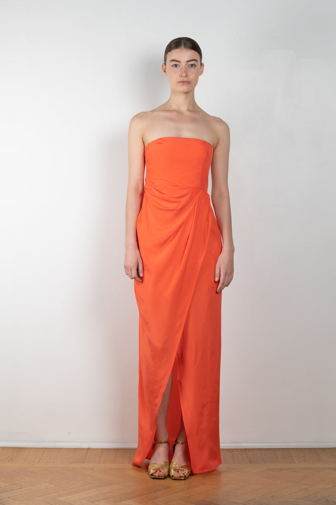 The Lica Long Dress by Gauge81 is a long silk bustier dress with front slit in a vibrant orange linen