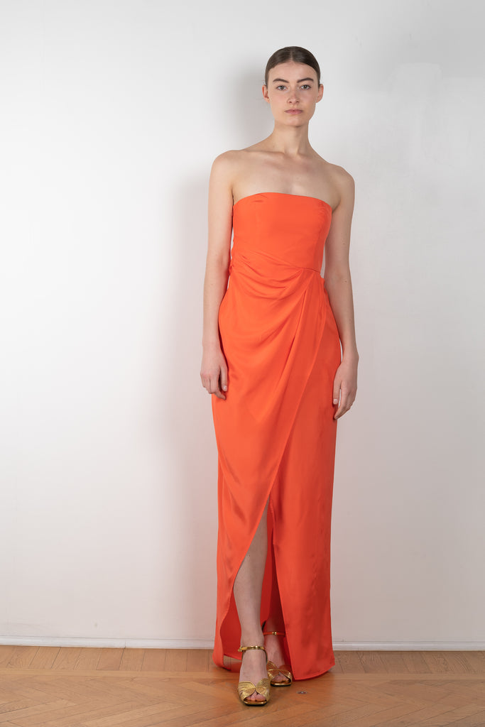 The Lica Long Dress by Gauge81 is a long silk bustier dress with front slit in a vibrant orange linen