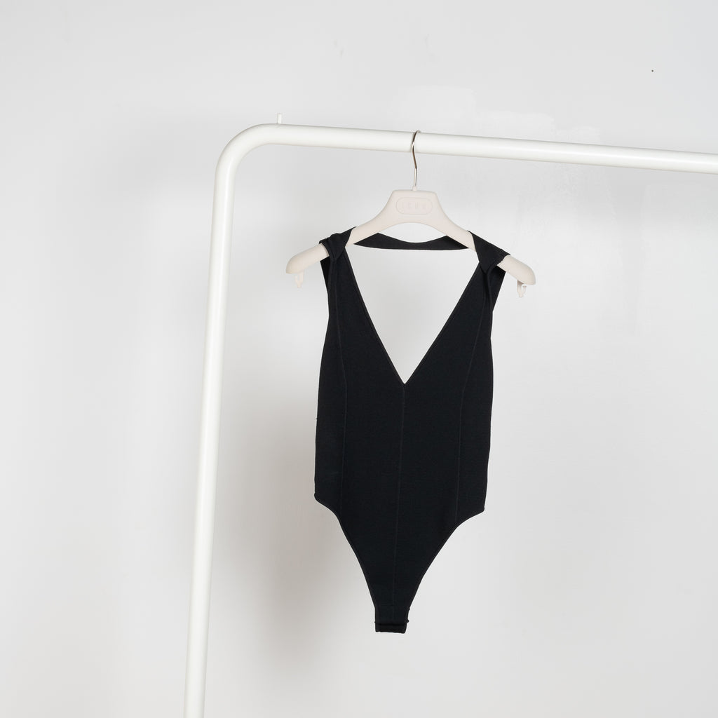 The Mezi Bodysuit by Gauge81 is a black bodysuit with a tan-colored mesh upper part