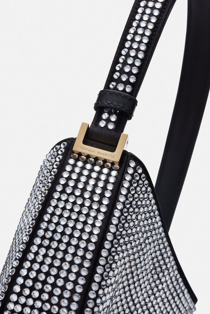 The Medium Vesna bag by Magda Butrym is a hobo bag with a classic yet trendy shape covered in crystals with a detachable signature strass brooch