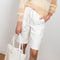 The Hadi Bermuda by Nanushka is a high waisted denim bermuda with vegan leather patch pockets on the back 