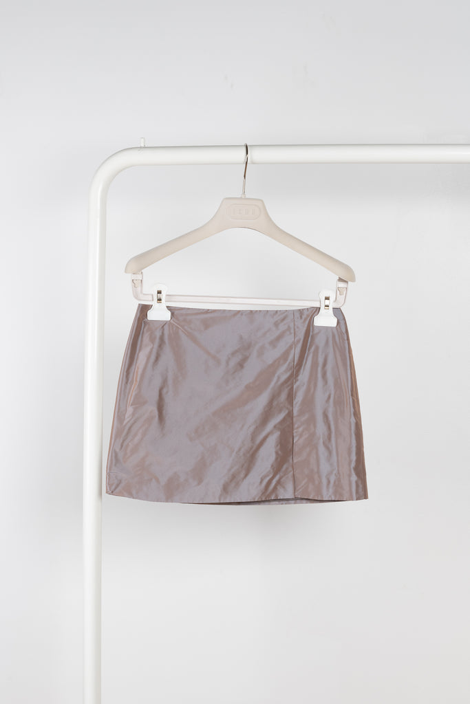 The Della Skirt by Rejina Pyo in Taffeta Iridescent is a fitted low waist mini skirt with a front side slit
