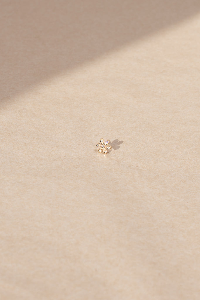 The Fiore Earring by Sophie Bille Brahe is a fine 18K yellow gold stud earring with 0.09 carats of Top Wesselton VVS diamonds in a delicate flower shaped setting