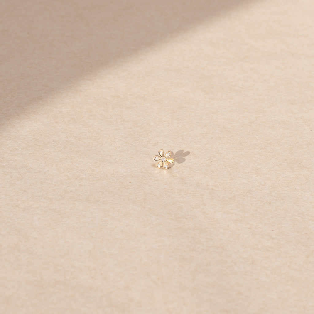 The Fiore Earring by Sophie Bille Brahe is a fine 18K yellow gold stud earring with 0.09 carats of Top Wesselton VVS diamonds in a delicate flower shaped setting