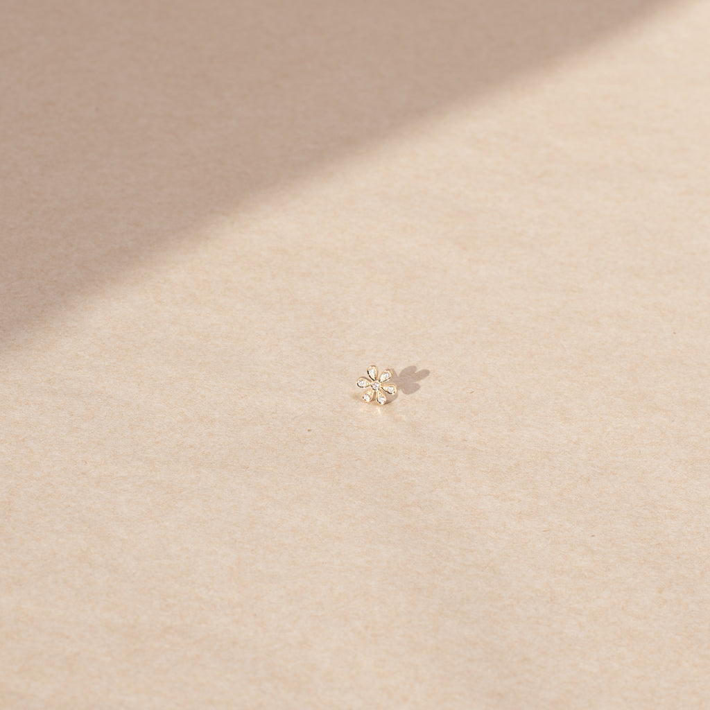 The Fiore Earring by Sophie Bille Brahe is a fine 18K yellow gold stud earring with 0.09 carats of Top Wesselton VVS diamonds in a delicate flower shaped setting
