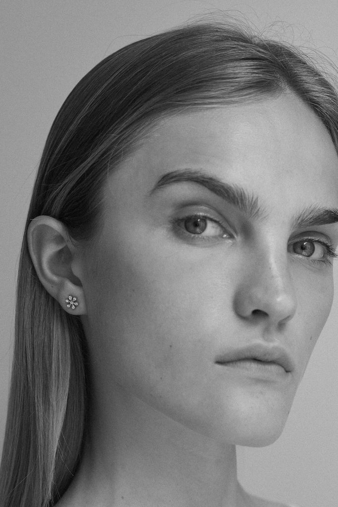 The Fiore Earring by Sophie Bille Brahe is a fine 18K yellow gold stud earring with 0.09 carats of Top Wesselton VVS diamonds in a delicate flower shaped setting