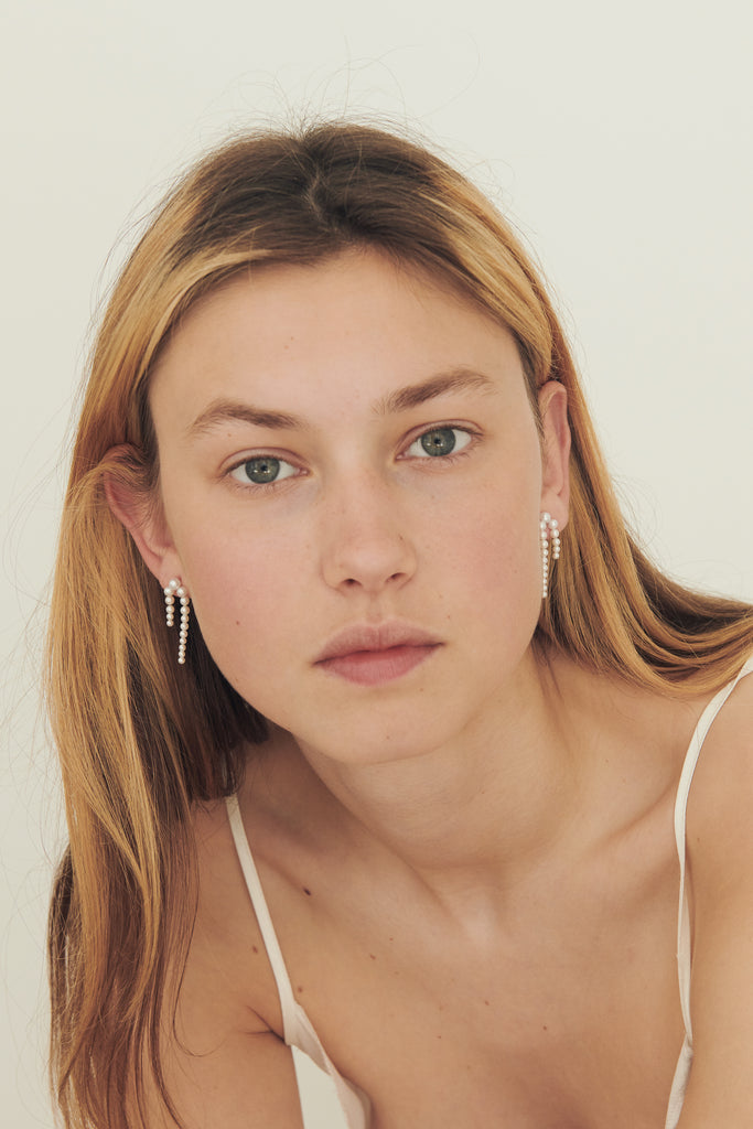 The Petite Perle Nuit Earrings by Sophie Bille Brahe are 14Kt Gold earrings with dropdown freshwater pearls descending in size