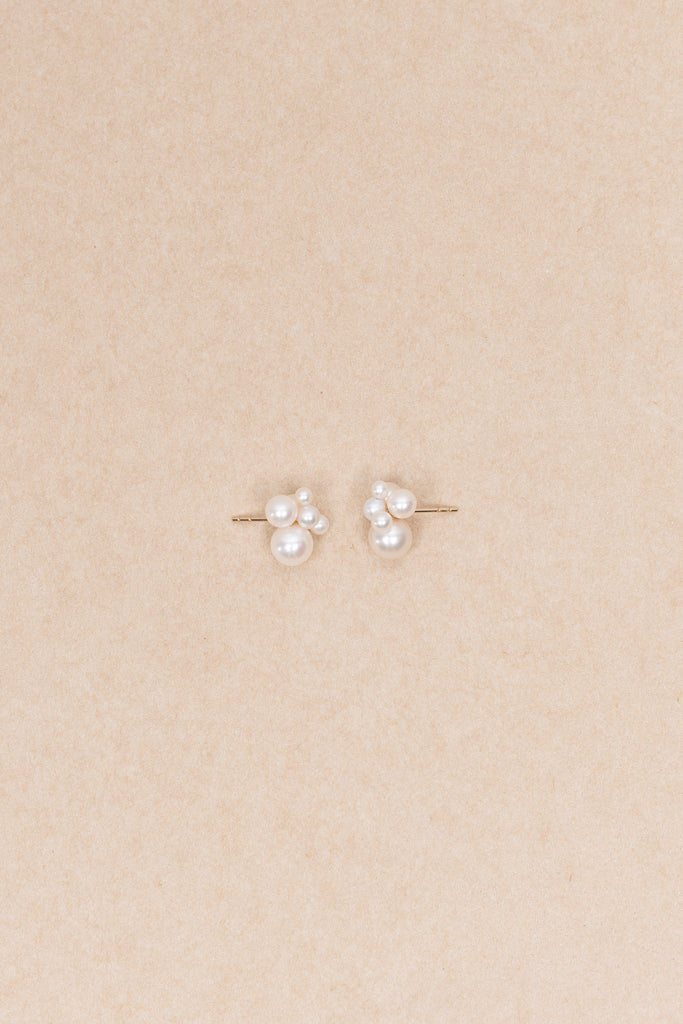 The Bisou Earring by Sophie Bille Brahe is a delicate stud earring in 14 Kt Gold with a small cluster of white freshwater pearls varying in size