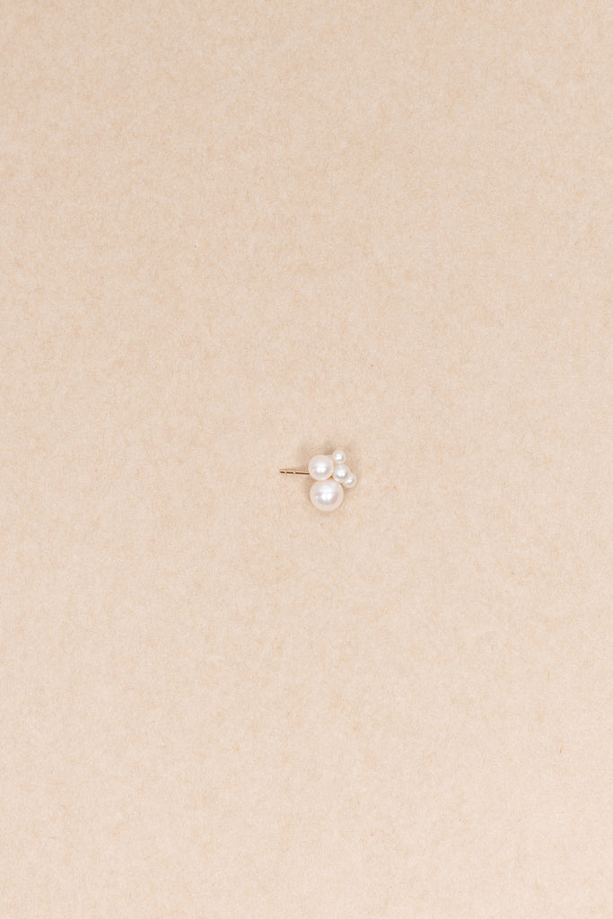 The Bisou Earring by Sophie Bille Brahe is a delicate stud earring in 14 Kt Gold with a small cluster of white freshwater pearls varying in size
