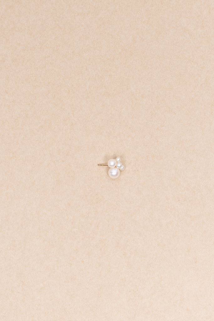 The Bisou Earring by Sophie Bille Brahe is a delicate stud earring in 14 Kt Gold with a small cluster of white freshwater pearls varying in size