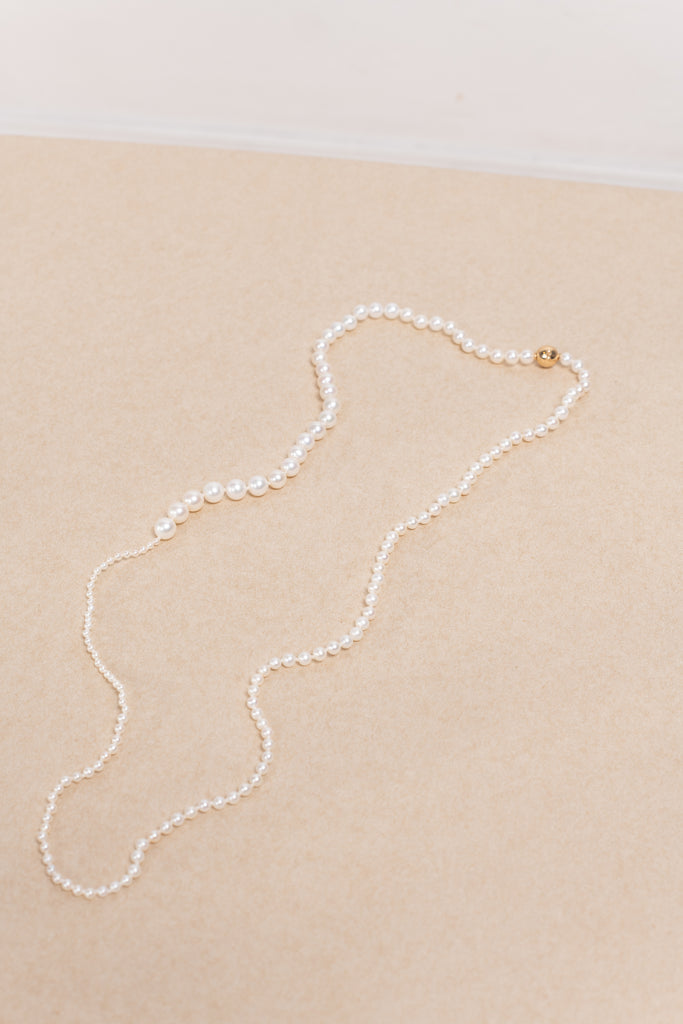 The Petite Peggy Perle Necklace is a longer version of the classic Petite Peggy Necklace with graduating sized Freshwater Pearls on an ancient Gold Lock