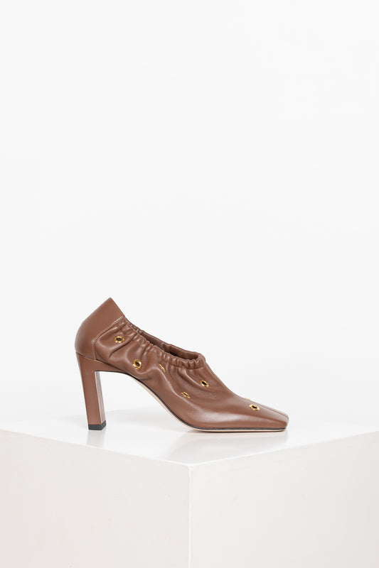 The Mia Mules by Wandler are block heel mules with soft voluminous pleats around the shoe and golden eyelets