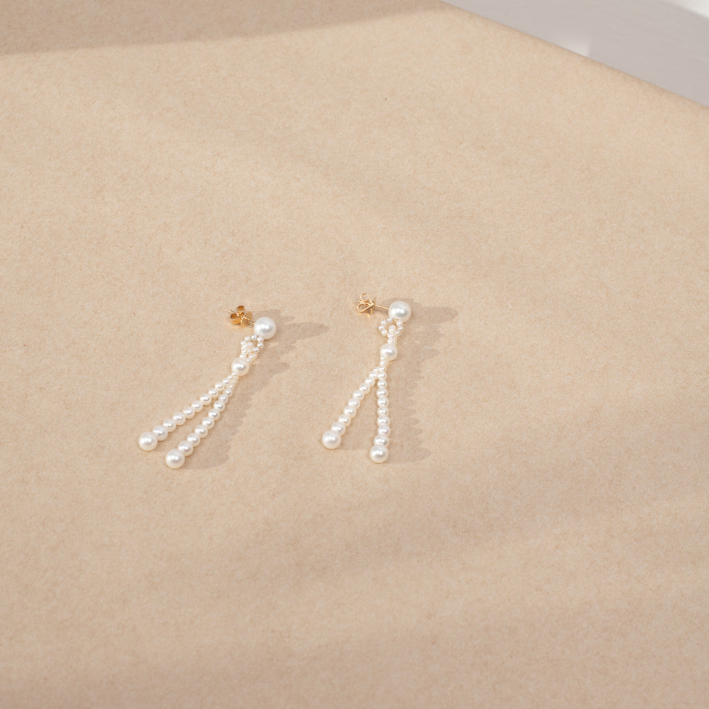 The Opera Earrings by Sophie Bille Brahe are statement drop earrings with white freshwater pearls graduating in size